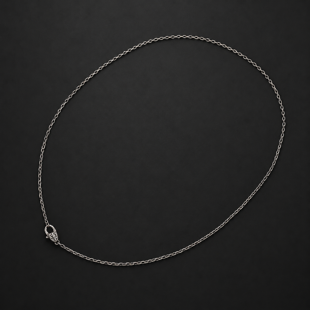 Gothic fine-link necklace chain with an ornate floral clasp on a dark background, 45–50 cm.